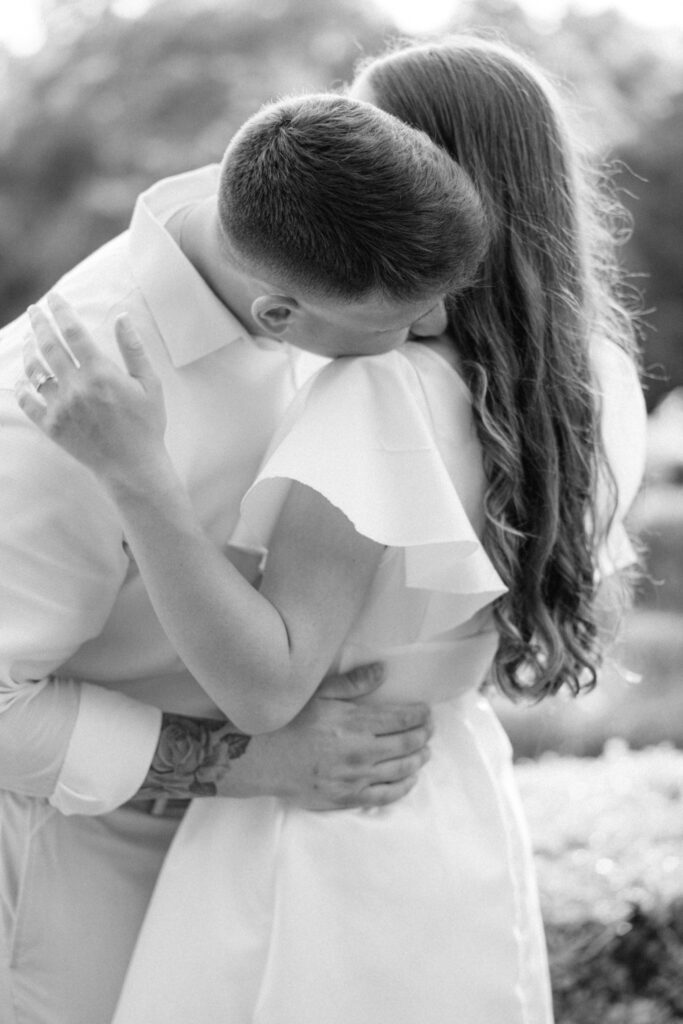 A black and white photo of a man kissing a woman at their Afton Villa Gardens engagement session