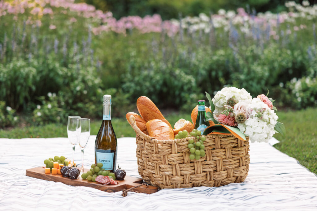 A picnic on the grass with wine and cheese at an Afton Villa Gardens engagement session