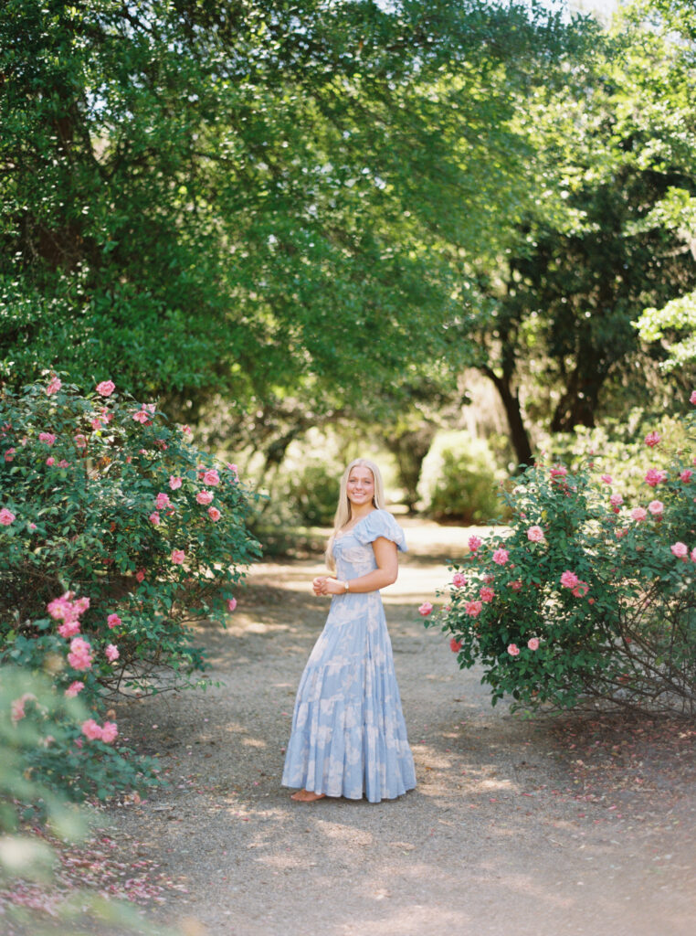 Amy standing in front of the blooming rose gardens at Rosedown Plantation during her senior session at Rosedown Plantation, photographed by Morgan Alysse Photography