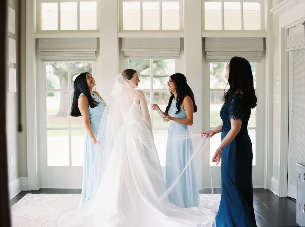 Bride getting ready with her mom and sisters in the bridal suite at Olivia and Landon's Oak Crossing Wedding in Lake Charles, LA, photographed by Morgan Alysse Photography.