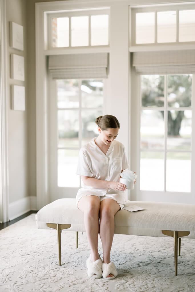 Bride opening a gift from the groom at Olivia and Landon's Oak Crossing Wedding in Lake Charles, LA, photographed by Morgan Alysse Photography.