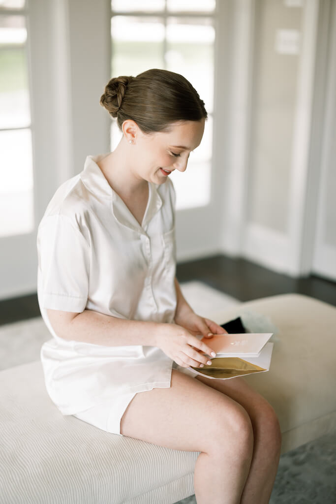 Bride reading a letter from the groom at Olivia and Landon's Oak Crossing Wedding in Lake Charles, LA, photographed by Morgan Alysse Photography.