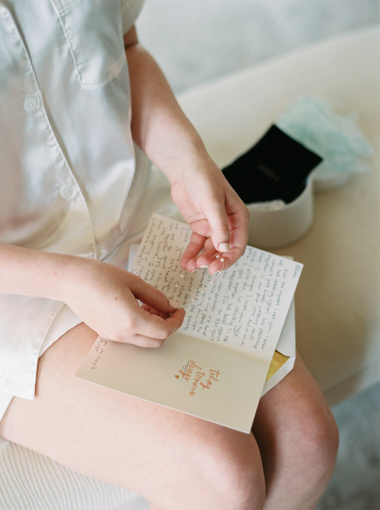 Bride opening a letter and gift from the groom at Olivia and Landon's Oak Crossing Wedding in Lake Charles, LA, photographed by Morgan Alysse Photography.