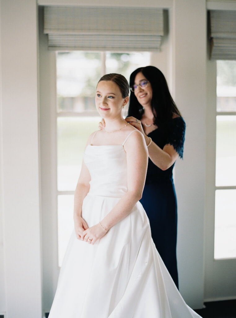 Bride getting ready with her mom  in the bridal suite at Olivia and Landon's Oak Crossing Wedding in Lake Charles, LA, photographed by Morgan Alysse Photography.