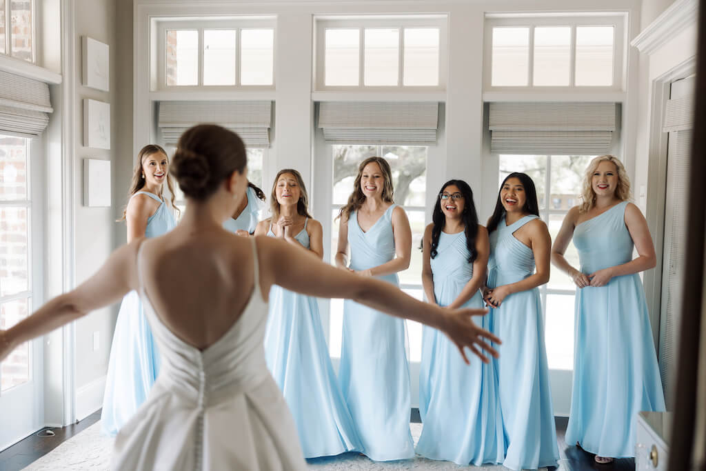 Candid portrait of bridesmaids reveal in the bridal suite as bridesmaids see the bride for the first time at Olivia and Landon's Oak Crossing Wedding in Lake Charles, LA, photographed by Morgan Alysse Photography.