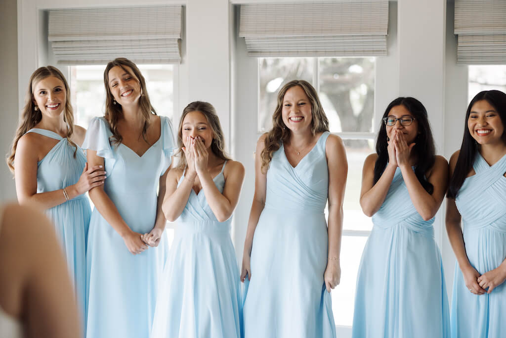 Candid portrait of bridesmaids reveal in the bridal suite as bridesmaids see the bride for the first time at Olivia and Landon's Oak Crossing Wedding in Lake Charles, LA, photographed by Morgan Alysse Photography.