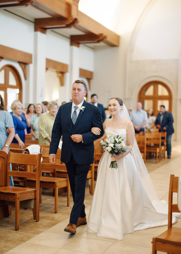 Bride walking down the aisle at St. Martin De Porres Catholic Church in Lake Charles, Louisiana, on Olivia and Landons Oak Crossing Wedding Day, photographed by Morgan Alysse Photography.