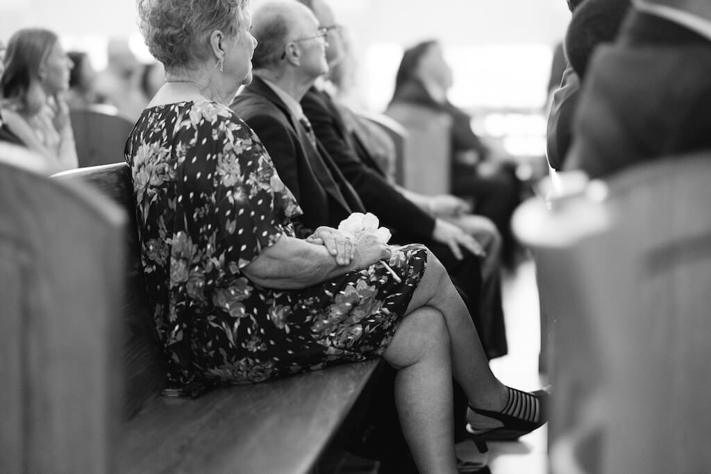 Grooms grandparents watching the bride walk down the aisle at St. Martin De Porres Catholic Church in Lake Charles, Louisiana, on Olivia and Landons Oak Crossing Wedding Day, photographed by Morgan Alysse Photography.