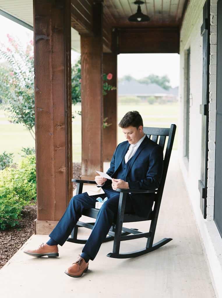 Groom opening a gift from the bride at Olivia and Landon's Oak Crossing Wedding in Lake Charles, LA, photographed by Morgan Alysse Photography.