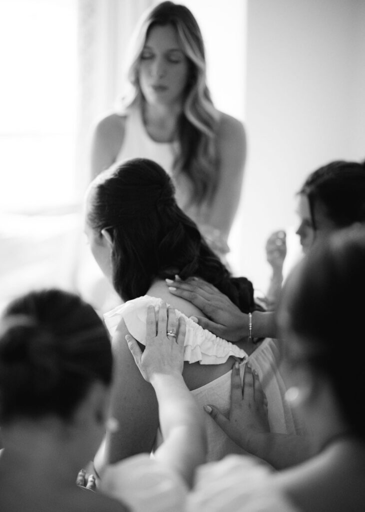 Bridesmaids praying with bride before Lauren and Colby's rainy day wedding at The Madison in Broussard, LA, photographed by Morgan Alysse Photography.