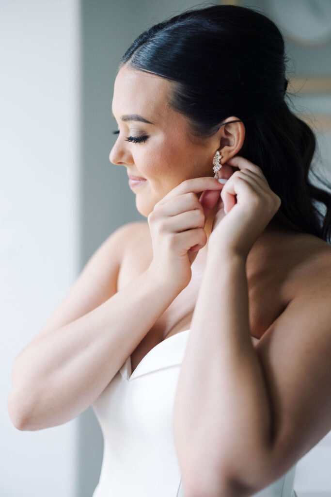 Bride getting dressed before Lauren and Colby's rainy day wedding at The Madison in Broussard, LA, photographed by Morgan Alysse Photography.