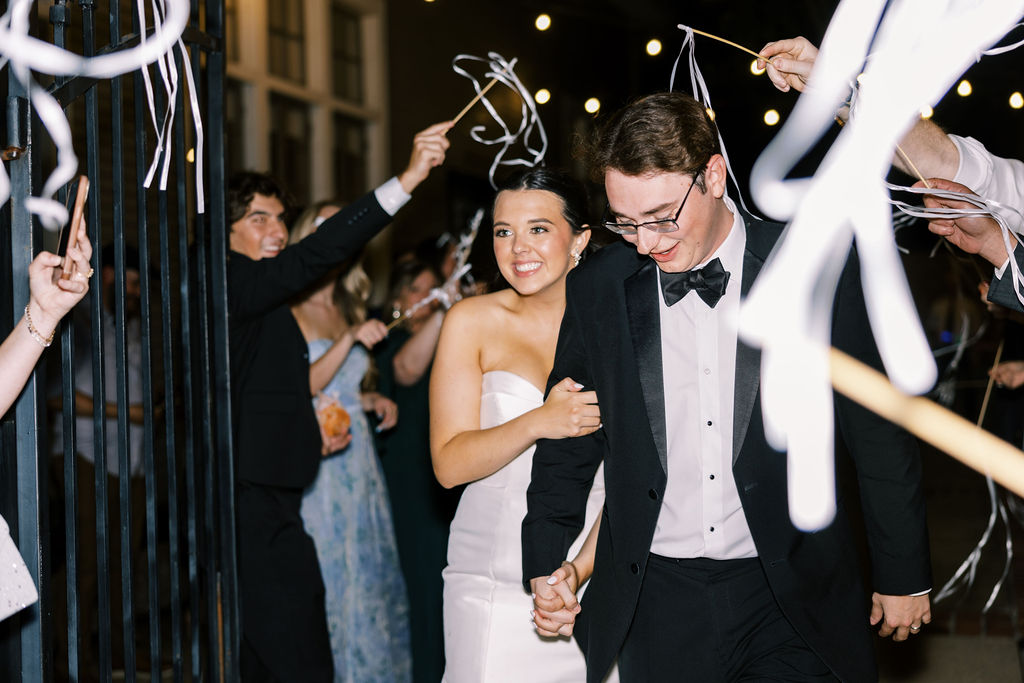 Bride and groom reception exit at Lauren and Colby's rainy day wedding at The Madison in Broussard, LA, photographed by Morgan Alysse Photography.