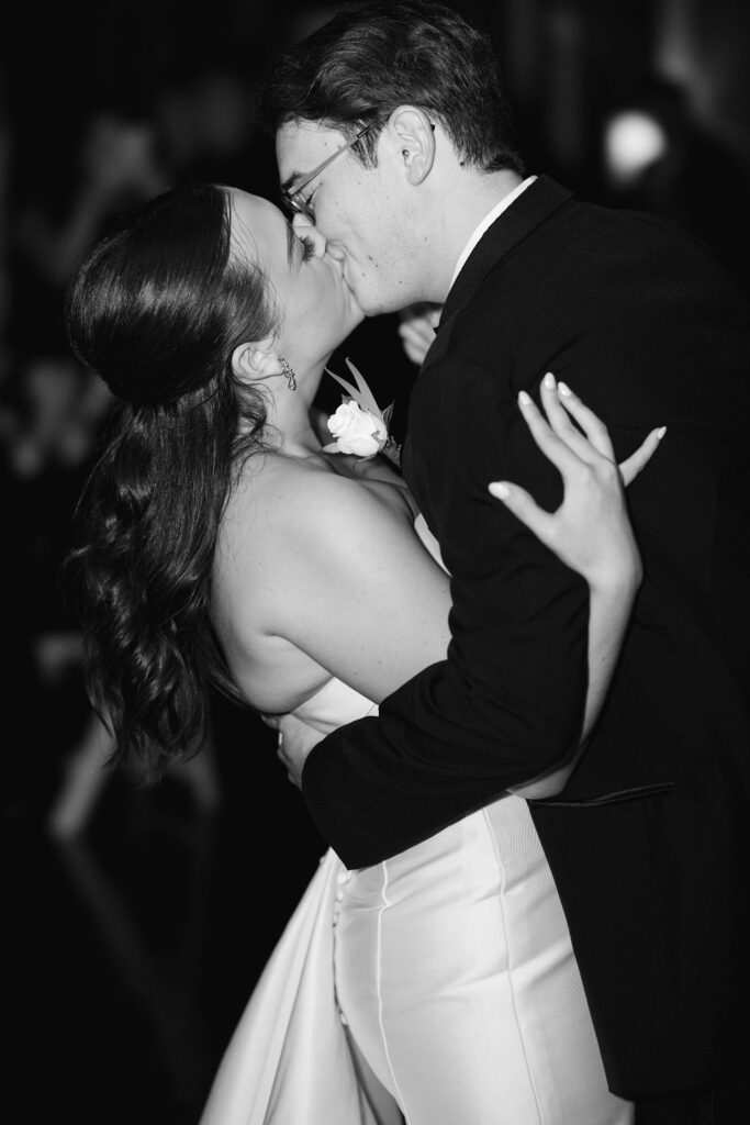 Black and white portrait of bride and groom kissing at Lauren and Colby's rainy day wedding at The Madison in Broussard, LA, photographed by Morgan Alysse Photography.