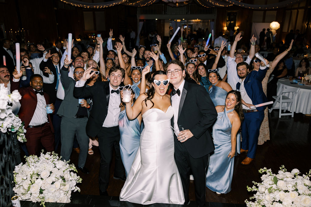 Bride and groom posing with large group at Lauren and Colby's rainy day wedding at The Madison in Broussard, LA, photographed by Morgan Alysse Photography.