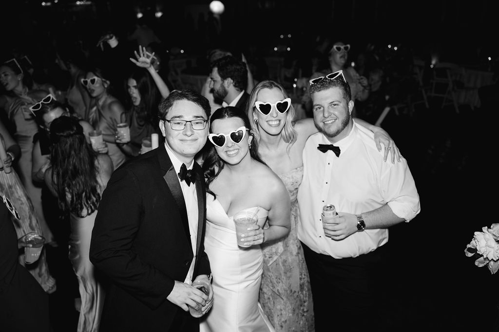 Bride and groom posing with guests at Lauren and Colby's rainy day wedding at The Madison in Broussard, LA, photographed by Morgan Alysse Photography.