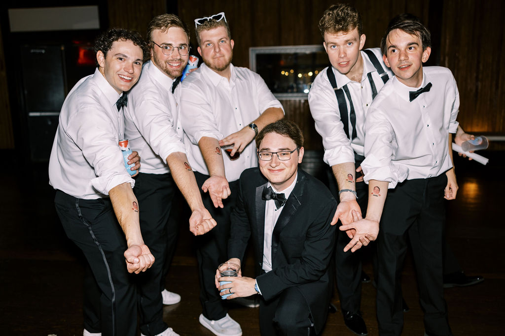 Groom with groomsmen with temporary tattoos at Lauren and Colby's rainy day wedding at The Madison in Broussard, LA, photographed by Morgan Alysse Photography.