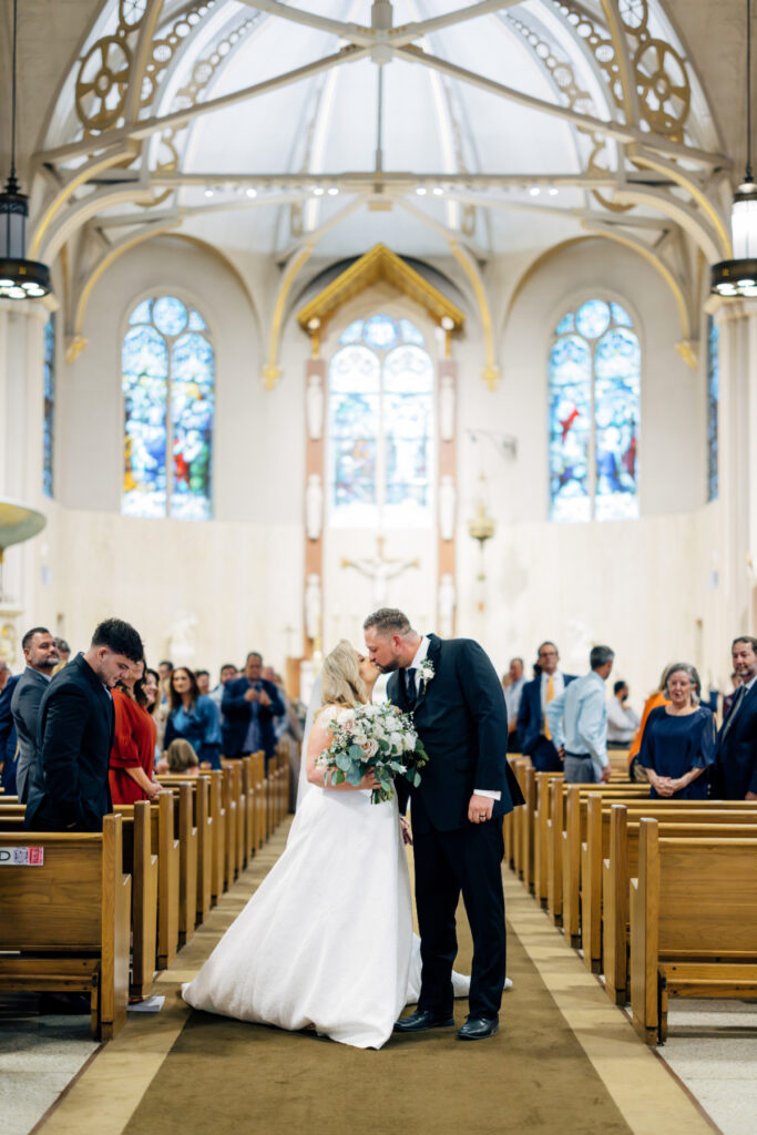 Bride and groom kissing at their wedding at St Landry Catholic Church captured by Morgan Alysse Photography