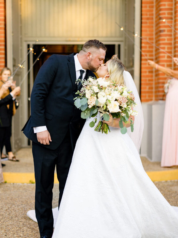 Bride and groom kissing at their wedding at St Landry Catholic Church captured by Morgan Alysse Photography