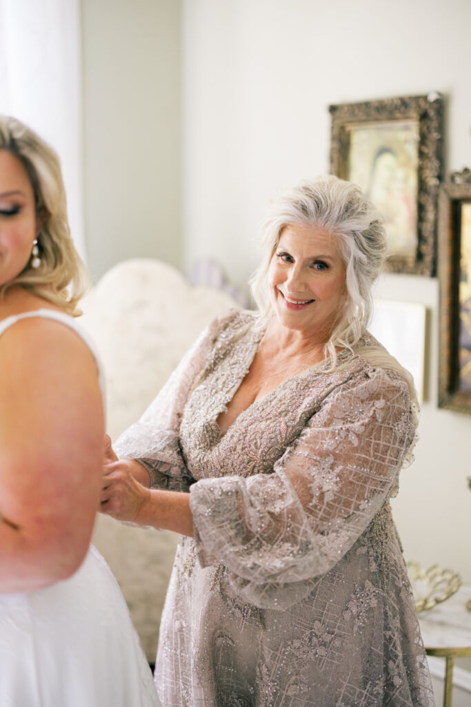 Bride getting dressed with her mother before her Opelousas wedding captured by Morgan Alysse Photography