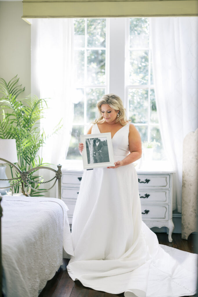 Bride holding a photo of her father before her Opelousas wedding captured by Morgan Alysse Photography