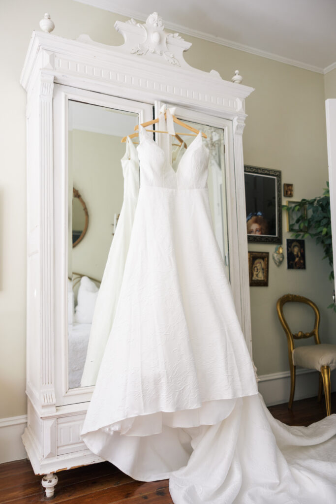 Wedding gown hanging on a mirrored wardrobe