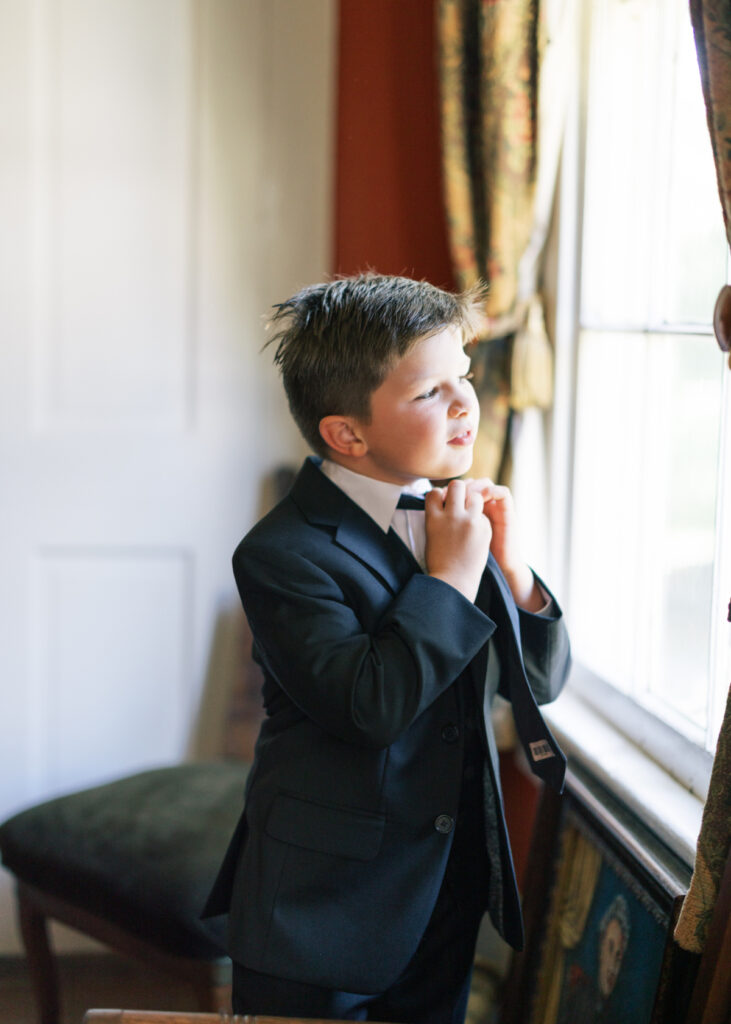 Bride's young son getting dressed before his mother's Opelousas wedding captured by Morgan Alysse Photography