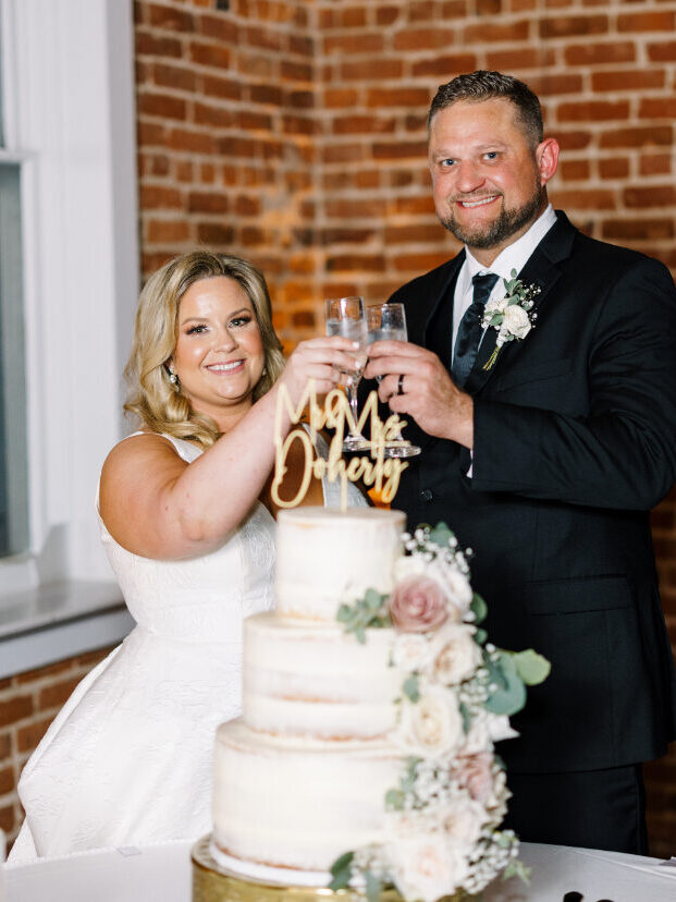 Bride and groom toast with their cake at their wedding reception at Wolff Banquets & Receptions captured by Morgan Alysse Photography