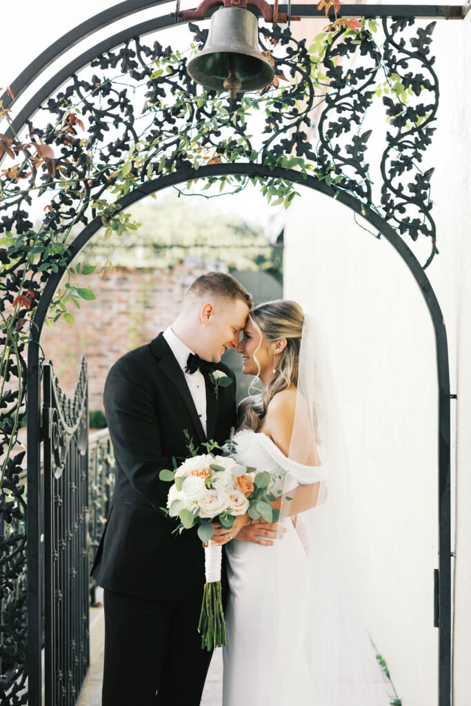 Bride and groom embracing in front of the historic architecture of Maison de Tours