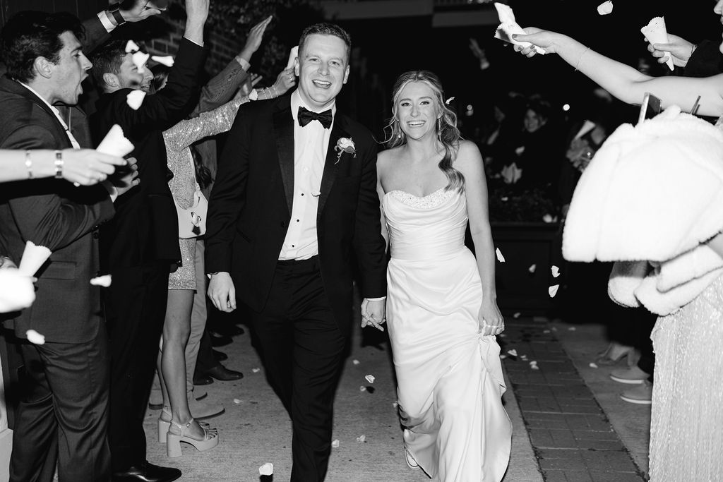 Guests cheering for the newlyweds at the end of the wedding reception