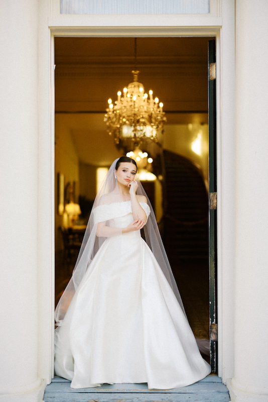 A timeless moment with a bride standing in the grand doorway of a plantation home.