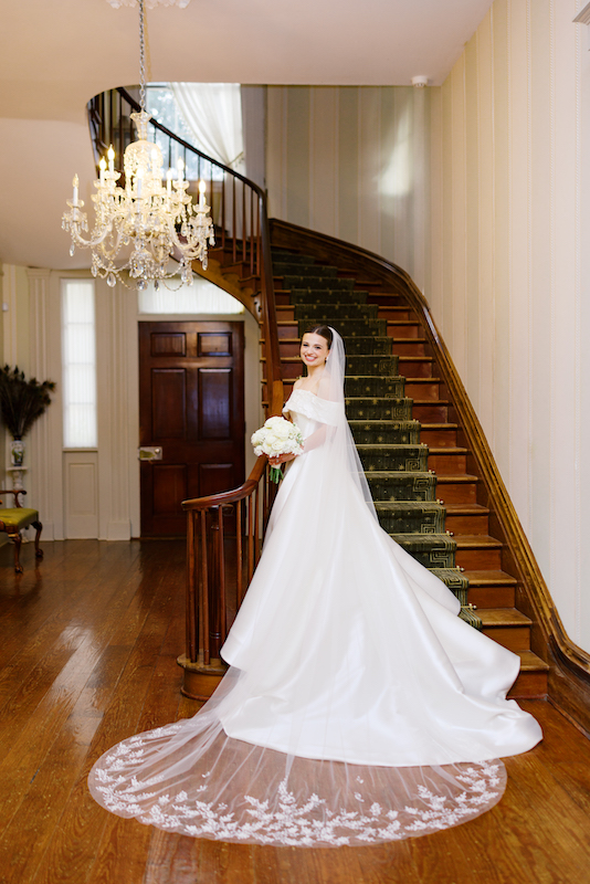 Bridal elegance captured on the historic wooden porch of a Louisiana mansion.