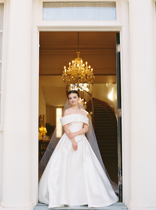 Bride standing under the massive oak trees draped in Spanish moss.