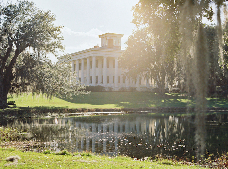 Soft golden light illuminating a bride on a historic Louisiana estate.